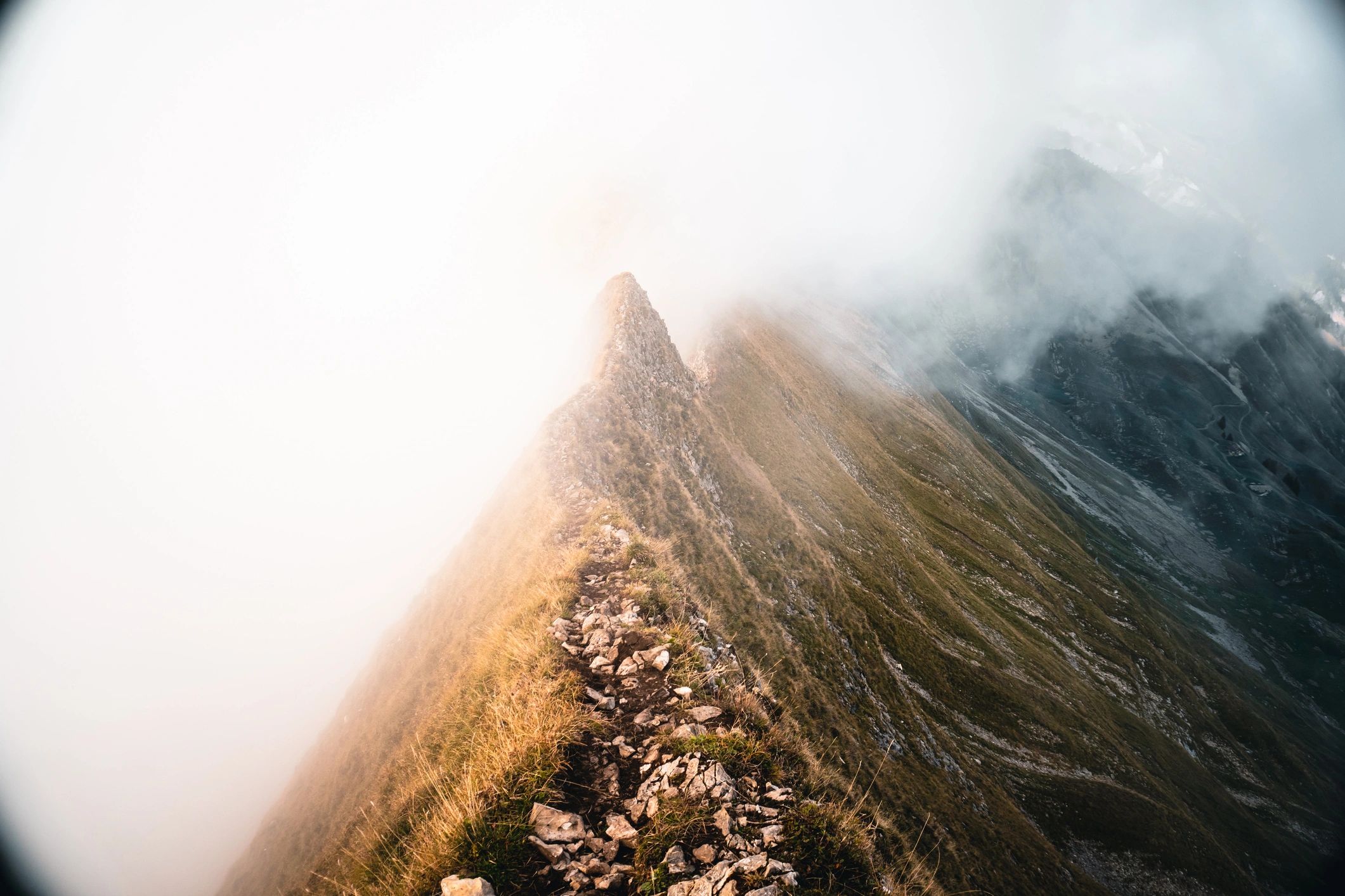 Mountain ridge trail above clouds at sunrise