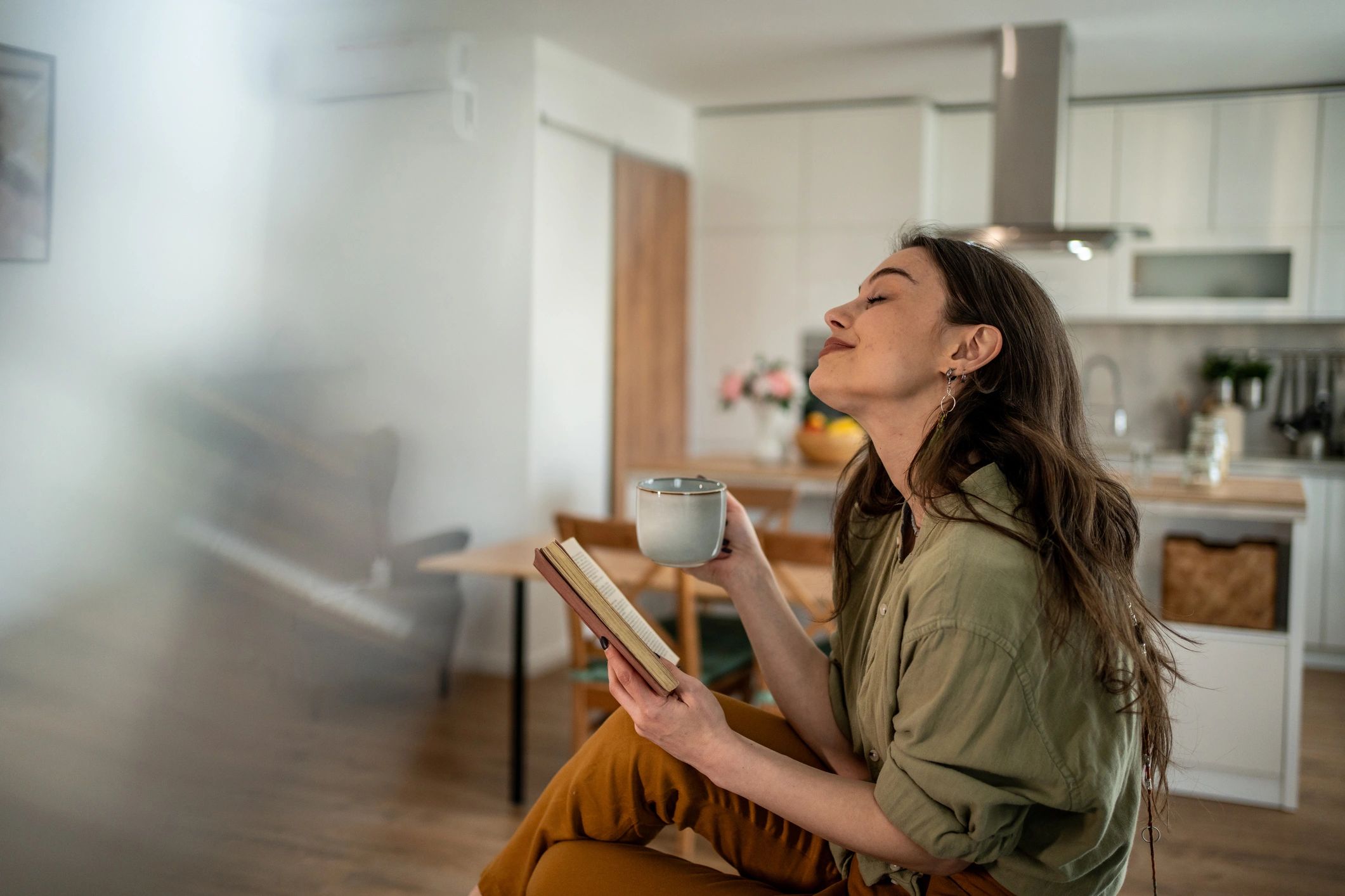 Person enjoying a quiet moment with tea and a book.
